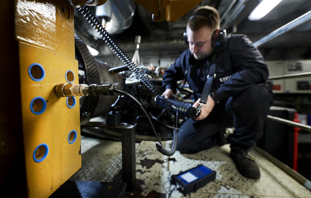 Tekniker måler maskine i industrimiljø